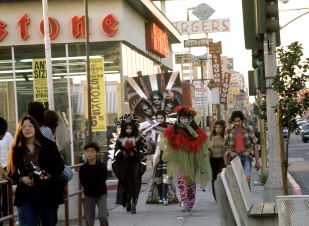 Walking Mural, 1972, printed 2011, Colour photograph by Harry Gamboa Jr., Pictured: Patssi Valdez, Willie F. Herrón III, Gronk, Courtesy Harry Gamboa Jr.